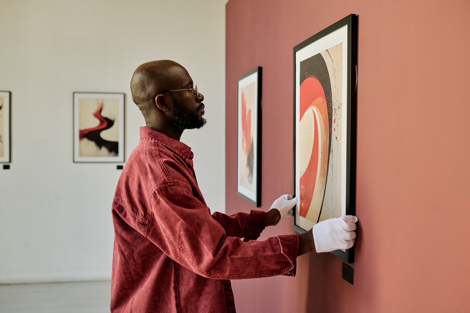 African American Man Examining Artwork in Gallery